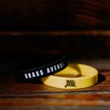 Černý a žlutý náramek Brass Avenue na dřevěném schodu