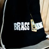 Detail černého batohu s logem Brass Avenue a bílými šňůrkami