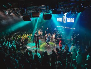 Pódium s logem Brass Avenue v tyrkysovém světle, kolem tančící publikum