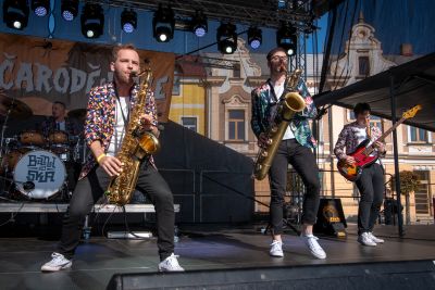 Dva saxofonisté v květovaných košilích na venkovním pódiu